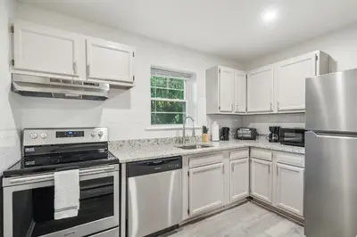 a kitchen with white cabinets and stainless steel appliances at Pine Brook 808 I Your Newark Retreat I Pool & Gym in Newark