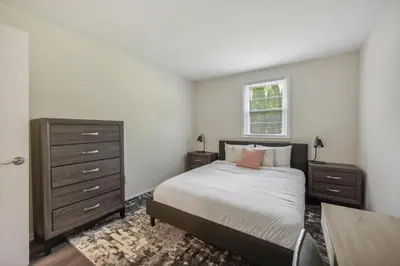 a bedroom with a bed and a dresser and a window at Pine Brook 816 I Corporate 2Br Apartment ! in Newark