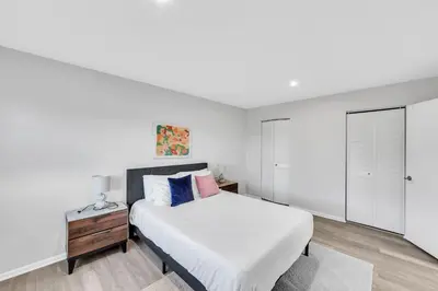 a white bedroom with a bed and a night stand at Pine Brook 817 I Corporate 1Br Apartment ! in Newark