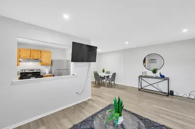 a white living room with a kitchen and a table at Pine Brook 817 I Corporate 1Br Apartment ! in Newark