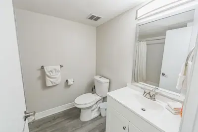 a white bathroom with a toilet and a sink at Pine Brook 817 I Corporate 1Br Apartment ! in Newark