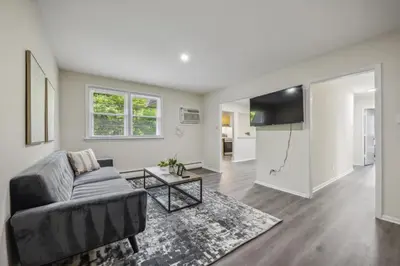 a living room with a couch and a table at Pine Brook 818 I Pool Gym I Free Parking ! in Newark