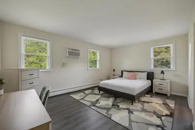 a bedroom with a bed and a desk and two windows at Pine Brook 818 I Pool Gym I Free Parking ! in Newark