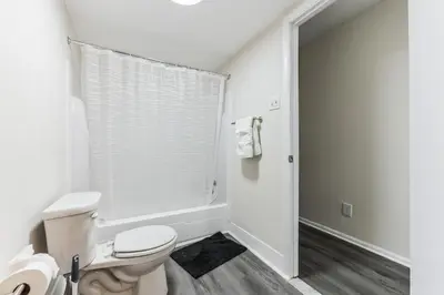 a white bathroom with a toilet and a shower at Pine Brook 818 I Pool Gym I Free Parking ! in Newark