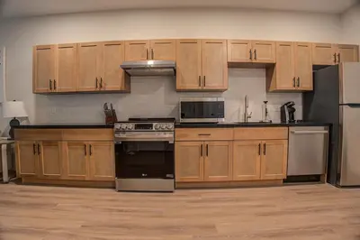 a kitchen with wooden cabinets and stainless steel appliances at Landing at Hagert and York 1 Bedroom in East Kensington in Philadelphia