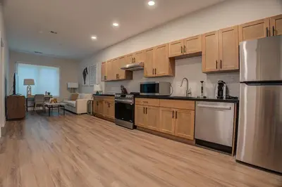 a large kitchen with wooden cabinets and appliances at Landing at Hagert and York 1 Bedroom in East Kensington in Philadelphia