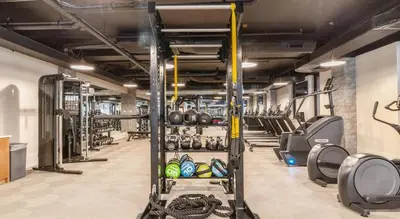 a gym with lots of treadmills and weights at Landing at Hagert and York 1 Bedroom in East Kensington in Philadelphia