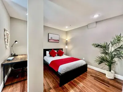 a bedroom with a bed with red pillows and a desk at 404 Rose in the city 1 BD living room in center city in Philadelphia