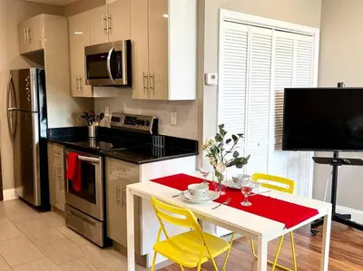 a kitchen with a white table and yellow chairs at 404 Rose in the city 1 BD living room in center city in Philadelphia