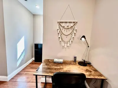 a room with a desk with a lamp and a chair at 404 Rose in the city 1 BD living room in center city in Philadelphia