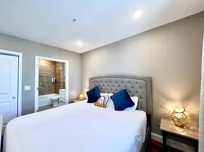 a bedroom with a large white bed with blue pillows at 403 Luxury and Comfy King bed in Central city of phily in Philadelphia