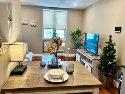 a living room with a table and a tv at 403 Luxury and Comfy King bed in Central city of phily in Philadelphia