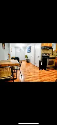 a living room with a table and a kitchen at Lovely Loft in Newark Minutes from NYC, EWR & American Dream Mall in Newark