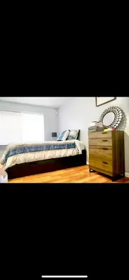a bedroom with a bed and a wooden dresser at Lovely Loft in Newark Minutes from NYC, EWR & American Dream Mall in Newark