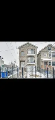 a large house with a fence in front of it at Lovely Loft in Newark Minutes from NYC, EWR & American Dream Mall in Newark