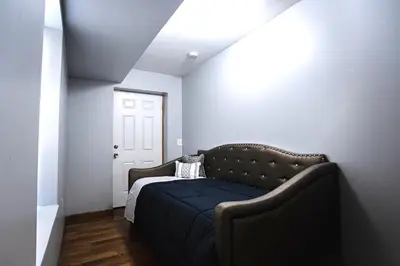 a bedroom with a bed with a blue blanket at Lovely Loft in Newark Minutes from NYC, EWR & American Dream Mall in Newark