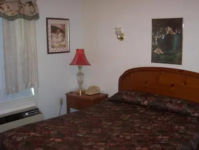 a bedroom with a bed and a lamp and a window at Grannys Motel Frackville in Frackville