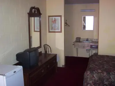 a hotel room with a bed and a television and a sink at Grannys Motel Frackville in Frackville