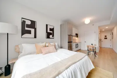 a bedroom with a large white bed with letters on the wall at One Grove in Jersey City in Jersey City