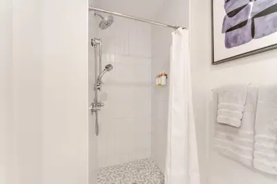 a bathroom with a shower with a shower curtain at One Grove in Jersey City in Jersey City