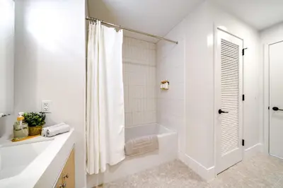 a white bathroom with a tub and a shower at One Grove in Jersey City in Jersey City