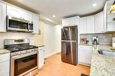 a kitchen with white cabinets and a stainless steel refrigerator at Your Perch at University City in Philadelphia