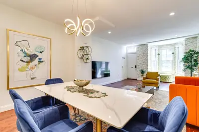a dining room with a white table and blue chairs at Your Perch at University City in Philadelphia