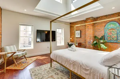 a bedroom with a large bed and a brick wall at Your Perch at University City in Philadelphia