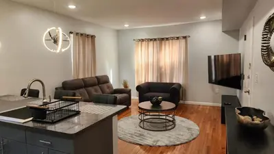 a kitchen and living room with a couch and a table at Comfortable Apartment in Irvington