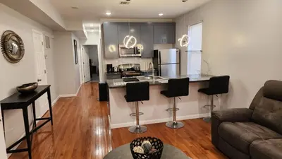 a living room with a couch and a kitchen at Comfortable Apartment in Irvington