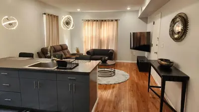 a kitchen with a counter top and a living room at Comfortable Apartment in Irvington