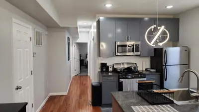 a kitchen with gray cabinets and a refrigerator at Comfortable Apartment in Irvington