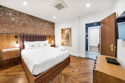 a bedroom with a bed and a brick wall at Landmarked NYC Townhome - Sleeps 10 -Group-Friendly in New York
