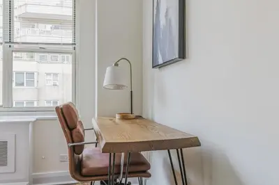 a table and a chair in a room with a window at Blueground Murray Hill gym lounge wd NYC-1565 in New York