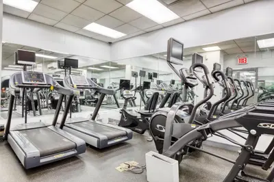 a gym with rows of treadmills and ellipticals at Blueground Murray Hill gym lounge wd NYC-1565 in New York