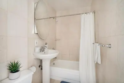 a white bathroom with a sink and a bath tub at 73-518 Newly Reno Studio UWS Doorman Gym Laundry in New York