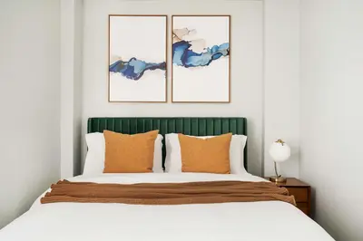 a bedroom with a bed with a green headboard at 73-608 New 1BR 1Bth UWS Doorman Gym in New York