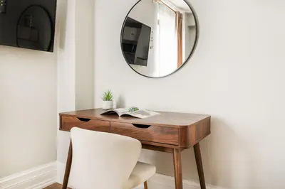 a dressing table with a mirror and a white chair at 73-608 New 1BR 1Bth UWS Doorman Gym in New York