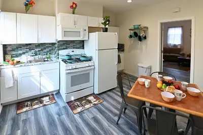 a kitchen with white appliances and a wooden table at Cozy Sanctuary in Jersey City
