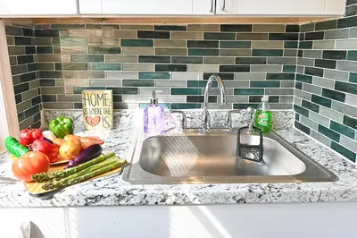 a kitchen sink with fruits and vegetables on a counter at Cozy Sanctuary in Jersey City