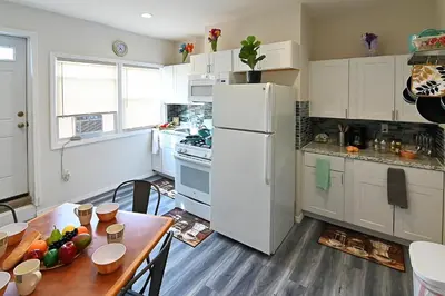 a kitchen with a table and a white refrigerator at Cozy Sanctuary in Jersey City