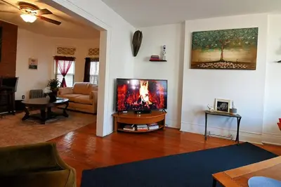 a living room with a large flat screen tv at Lovely Victorian Home with Bed and Breakfast Energy in West Bergen