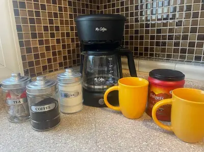 a coffee maker and coffee cups on a counter at Lovely Victorian Home with Bed and Breakfast Energy in West Bergen