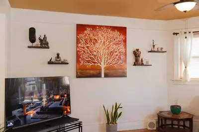 a tv in a living room with a tree on the wall at 3 Bedroom Gem! King, Full & Twin Beds, Sauna with Free Parking plus more in Jersey City