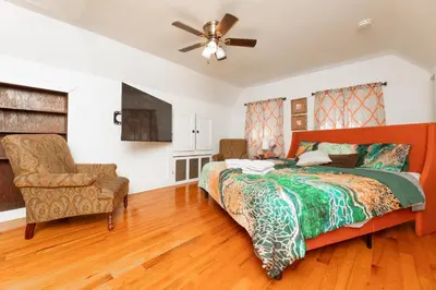 a bedroom with a bed and a fan and a chair at 3 Bedroom Gem! King, Full & Twin Beds, Sauna with Free Parking plus more in Jersey City