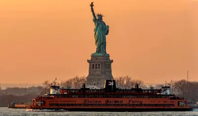 a boat in the water near the statue of liberty at New York City Apartment Near Free Ferry Boat! in Stapleton