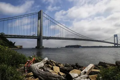 a bridge over the water with a bike parked in front at New York City Apartment Near Free Ferry Boat! in Stapleton