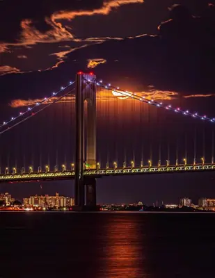 a bridge over the water at night at New York City Apartment Near Free Ferry Boat! in Stapleton