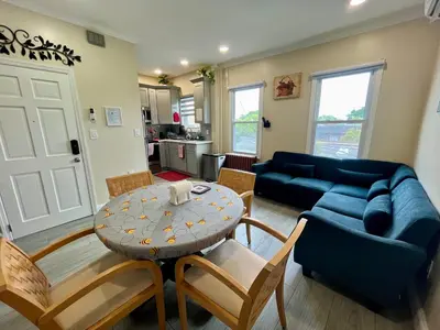 a living room with a blue couch and a table at New York City Apartment Near Free Ferry Boat! in Stapleton