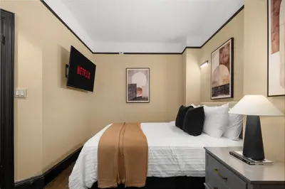 a hotel room with a bed and a desk with a lamp at Stunning Apt in The Heart of New York City GYM in New York